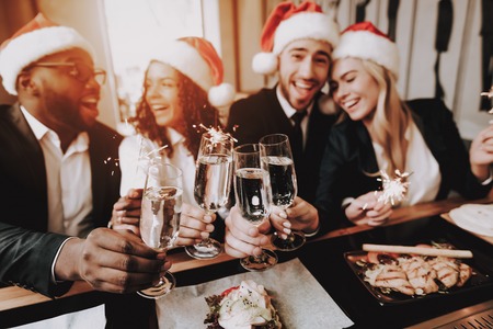 Santa's Hat. Nightlife. Young People. Rest. Bar. Girls and Guys. Drink Alcoholic Beverages. Different Races Communicate. Have Fun. Together. Clubbing. Joyful. Chin-chin. Leisure. Positive. Emotion.の写真素材