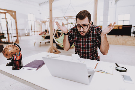 Stress. Brainstorm. Young Guy. Businessman. Working in Office. Creative Worker. Creates Ideas. Laptop. Sit. Businesspeople. Workplace. Inspiration. Toy. Relaxation. Hobby. Comfortable Office.の写真素材