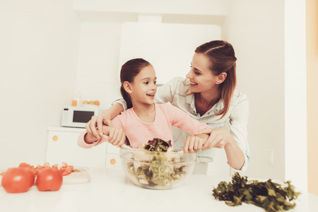 Happy Family Is Preparing A Salad At Kitchen. Relationship Concept. Having Fun During The Cooking. Morning Nutrition. Parent Duty. Happy Childhood Concept. Time To Lunch. Vegies Mixing.の写真素材