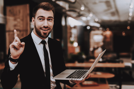 Posing. Business Suit. Laptop. Sit. Brainstorm. Young Guy. Businessman. Working in Office. Creative Worker. Creates Ideas. Businesspeople. Workplace. Inspiration. Relaxation. Comfortable Office.の写真素材