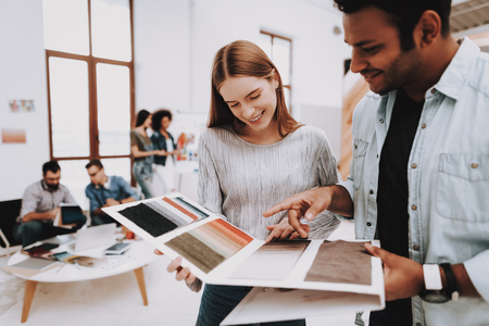Project. Guy and Girl. Talking. Young Specialists. Designers. Choose Colors for Design. Work Together. Office. Teamwork. Discussion. Brainstorming. Design Studio. Multi-Ethnic. Creative. Workplace.の写真素材