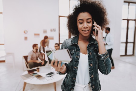 Phone. Curly-Haired. Mulatto. Girl. Office. Samples of Colors. Paper Cup. Choose Colors for Design. Men. Designers. Brainstorming. Design Studio. Multi-Ethnic. Project. Creative. Workplace.の写真素材