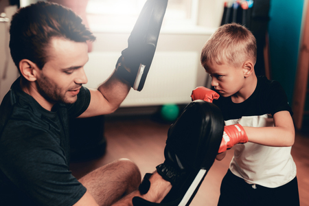 Father And Son Boxing Exercises Training In Gym. Parenthood Relationship. Sporty Family Concept. Active Lifestyle. Kid In Boxing Gloves. Holiday Leisure. Working Out Together. Fitness Day.の写真素材