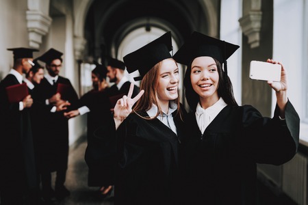 Black Mantles. Selfie. Architecture. Happiness. Girls. Intelligence. Diploma. University. Graduate. Happy. Good Mood. University. Cheerful. Celebration. Cap. Campus. Man. Knowledge. Mortar Board.の写真素材
