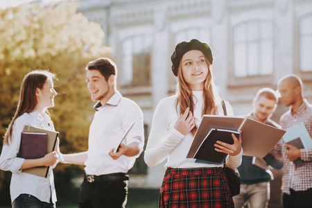 University. Knowledge. Redhead. Coffee. Happy. Standing in University. Good Mood. Courtyard. Books. Architecture. Happiness. Girl. Intelligence. Diploma. Celebration. Campus. Man. Friends. Students.の写真素材