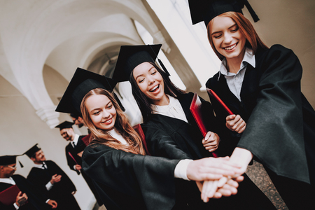 Celebration. Girls. Cap. Architecture. University. Campus. Cheerful. Happiness. Intelligence. Diploma. Standing. Corridor. University. Robes. Graduate. Happy. Good Mood. Man. Knowledge. Mortar Board.の写真素材