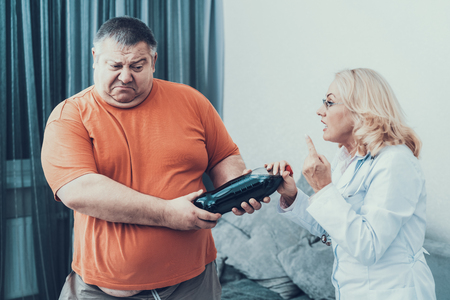 Fat Man with Doctor in White Coat With Cola. Woman in White Coat. Diet and Healthcare Concept. Man with Bulimia. Unhealthy Lifestyle Concept. Man with Overweight. Patient with Bottle.の写真素材