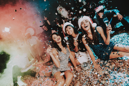 Three Young Women Celebrating New Year on Party. Santa Claus Cap. People in Red Caps. Happy New Year...