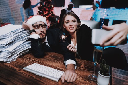 Tired Man and Happy Girl in Office on New Year Eve.