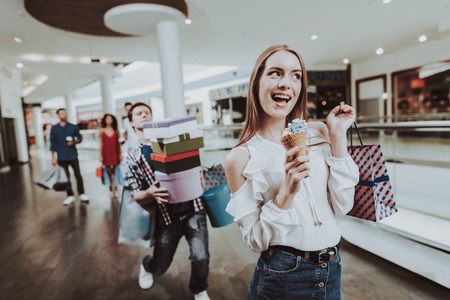 Carefree Woman with Ice Cream in Hand in Mall.