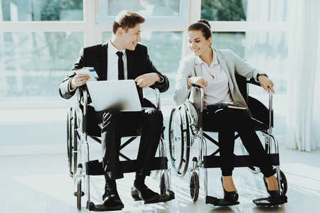 Person in Wheelchair. Woman Disabled. Panoramic View. White Interior. People with Limited Opportunities. Business Meeting. Business Clothes. Business Trip. Greeting Friends Disabled. Man in Wheelchairの写真素材