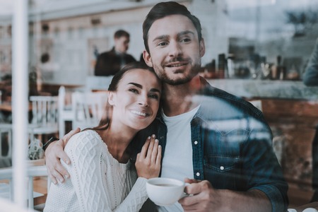Hugging. Love. Drink Tea. Have Fun. Tea Party. Smiling People. Enjoyment. Guy and Girl. Bonding. Together in Cafe. Cheerful Girl. Happy Together. Leisure Time. Good Relationship. Happy Holidays.の写真素材