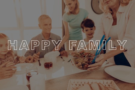 Salad. Holiday. Happy Family. Thanksgiving Day. Cups of Tea. Big Family. Dinner Table. Woman. Plate. Blue Shirt. Traditional Dinner. Have Fan. Together at Home. Celebrating Holiday. Delicious Food.の写真素材