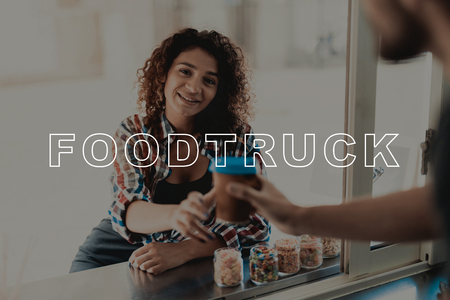 Girl In A Plaid Shirt Buys Coffee In A Food Truck. Black Beard. Ready To Work. Fast Eating Place. Service Personal. Opened Window. Professional Work Uniform. Sunny Day. Big City Life.の写真素材