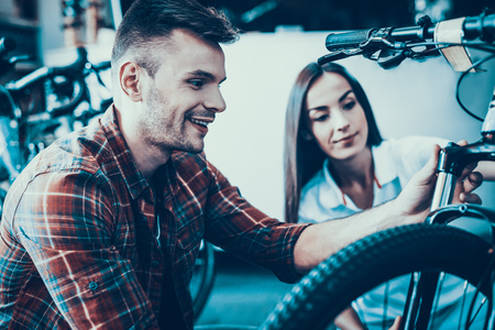 Girl Consultant Shows Cycle to Buyer in Sport Shop.の写真素材