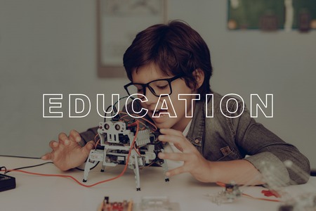 Smart Little Kid In Glasses Is Creating A Robot. Plaid Flannel. Home Leisure.