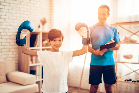Boy Standing on Scales. Father and Son do Spotting. Sport at Home.の写真素材