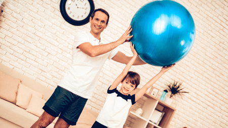 Blue Fitball. Sport at Home. Gym Mat. Doing Sports. Man and Boy Train at Home.の写真素材