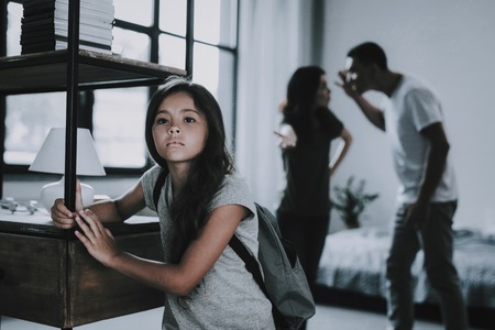 Sad Girl Listens How Parents Arguing at Home.の写真素材