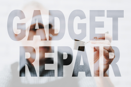 Computer Repairman Examines Microchip through Magnifying Glasses. Technician Master at PC Service Workshop. Transparent Text Effect. Concept of the Gadget Components Repair. Worker Fixing CPU.の写真素材