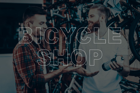 Bicycle Shop. Salesman Showing the Water Bottle to Customer. Water Bottle for Bicycle. Customer Choosing the Water Bottle on His Bike. Hipster Male Salesman. People Happy and Smiling.の写真素材