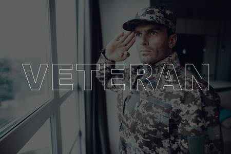 Military Veteran. Man Standing in Front of Window. Large Panoramic Window. Man is Soldier. Soldier...