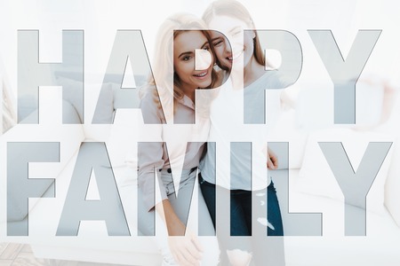 Happy Family. Mother and Daughter Doing Selfie on Mobile Phone. Mother and Daughter Smiling for Photography. Mother and Daughter Hugging Each Other. People Located in Home Apartments.の写真素材