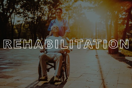 People Walk in Sunset. Outdoor Rehabilitation. Doctor and Patient Walk. Man Sit in Wheelchair. Good Medicine in Nursing Home. Disabled in Wheelchair. Smiling Old Man in Park. Man Retirement.の写真素材