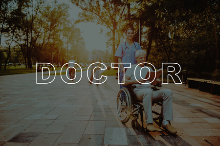 People Reading Book at Sunset. Doctor and Patient Walk. Outdoor Rehabilitation. Man Sit in Wheelchair. Good Medicine in Nursing Home. Disabled in Wheelchair. Smiling Old Man in Park. Man Retirement.の写真素材