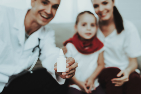 Doctor Visiting Little Girl in Red Scarf with Cold. Sick Young Girl. White Sofa in Room. Doctor in Uniform. Disease Concept. Healthcare and Healthy Lifestyle Concept. Mother with Daughter.の写真素材