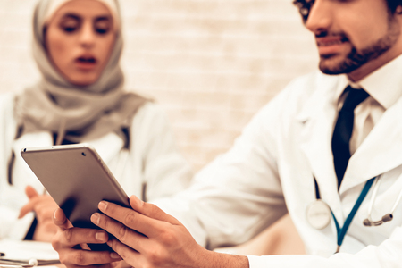 Medical Consultation Arabic Pediatricians Doctors. Muslim Doctors Using Smart Device in Office. Child at the Pediatrician. Hospital Concept. Healthy Concept. Child Patient Visiting Doctor. Healthcare And Medicine.の写真素材