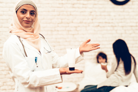 Portrait Arabic Female Doctor Holding Medicament. Smiling Muslim Female Doctor. Child at the Pediatrician. Hospital Concept. Healthy Concept. Child Patient Visiting Doctor.の写真素材