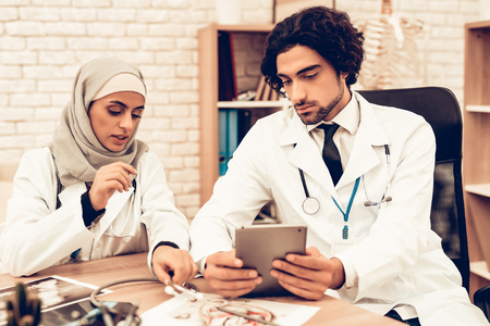 Medical Consultation Arabic Pediatricians Doctors. Muslim Doctors Having Consultation in Office. Arabic Doctors Holding X-Ray, Medical Consultation. Hospital Concept. Healthy Concept. Healthcare And Medicine.の写真素材