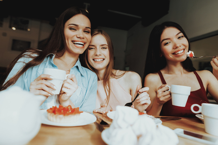 Happy Girl Smile and Eat Fod and Celebrate 8 March. Enjoy People Smile in Happy DAy 8 March. Party amd Cake with Tea in Day 8 March. Womens Day and Good Time Together. Solemn Day For all Young Girls.の写真素材