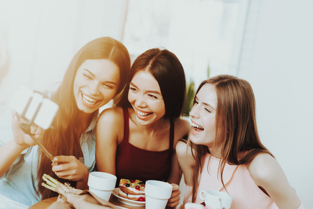 Women Smiling with Tea. Women Smile. Young Woman Play Happy. Beautiful 8 March with People. Flowers and Happy Women. Springtime for Love Women. Birthday with Friends. Birthday and Happy.の写真素材