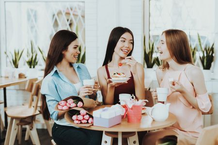 Beautiful Womens and Springtime Smile People Drinking Tea. Beautiful Flowers and Good Tea. Friend Drinking Tea and Smile. Happy Time with Together. Present for Beautiful Women. Care for Young Girl.の写真素材
