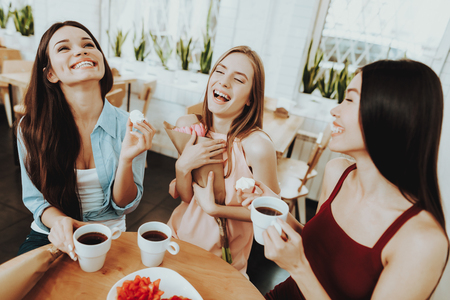 Happy Woman Drinking Tea with Biscuit. Springtime with Tea and Biscuit. Celebrate 8 March with Family and Friends. Tenderness and Happy in this Day for all Women. Beautiful Woman with Young Girl.の写真素材