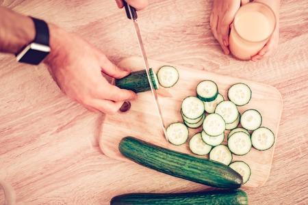 Cook Food at Home. Happy Family. Father's Day. Girl and Man Cook Food. Man and Child at Table. Spend Time Together. Sliced Tomatoes on Board. Vegetables on Board. Cut Vegetables. Tomatoes and Cucumberの写真素材