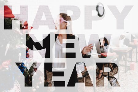 Office Workers Posing In Workplaces On New Year. Team Working. Good Festive Mood. Celebrating Together. Holidays At Work. Happy Colleagues. Bright Garlands. Ready To Corporate. Cheerful Women.の写真素材