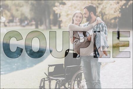 Couple in Love. Man and Disabled Girl in Park. Handsome Man holding Beautiful Girl next to Wheelchair. Attractive Man and Disabled Woman on Romantic Date. Love and Relationship Conceptの写真素材