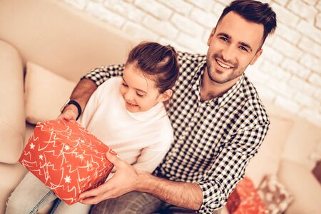 Father and Daughter on Sofa. Spend Time Together. Father's day. Man Play with Girl. Smiling Girl at Home. Sit on Sofa.の写真素材
