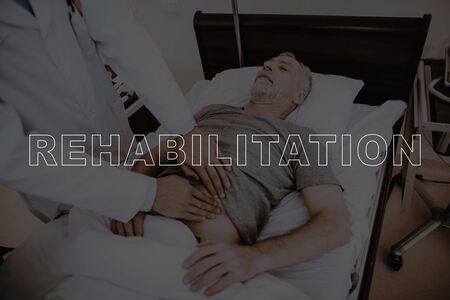 Collage Rehabilitation Doctors Examine Patient. Old Man Lying in Modern Hospital Bed. Male Hands on...