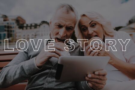 Old Couple Eat Burgers. Couple Love Story. Man Hold Tablet. Woman Smiling. Retired People Happy...
