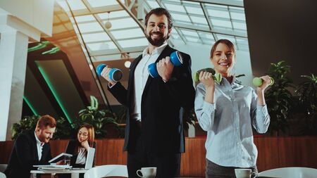 Corporate Sport Lifestyle. Healthcare of Business People. Office Workers Working with Dumbbells. Workers doing Fitness Exercises. Yoga Practice. Employee Man Smiling to Healthy Woman.の写真素材