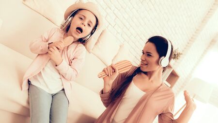 Mother Have Fun with Daughter. Kids Home Games. Learning at Home. Child Development. Mom and Daughter Sing. Girl in Headphones Dancing. Happy Mom and Child in Pajamas. Child with Comb in Hand Sings.の写真素材
