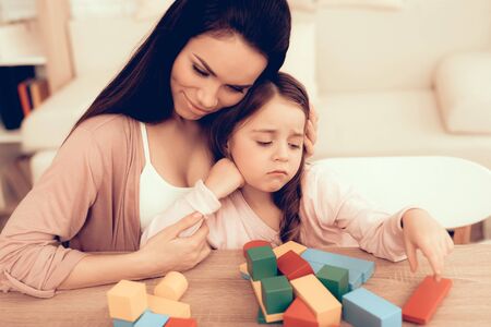 Mom Teaches Daughter. Educational Games. Learning Child at Home. Build House of Cubes. Woman and Sad Child. Child Development.の写真素材