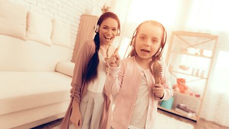Mother Have Fun with Daughter. Kids Home Games. Learning at Home. Child Development. Mom and Daughter Sing. Girl in Headphones Dancing. Mom and Girl in Pajamas. Child with Comb in Hand Sings.の写真素材
