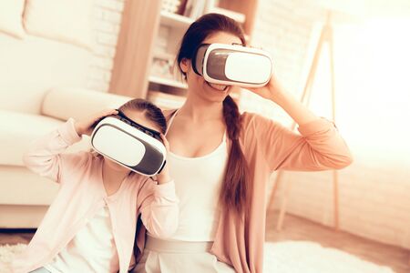 Mother Have Fun with Daughter. Kids Home Games. Learning at Home. Child Development. Mom and Daughter Play. Girl in Virtual Reality Glasses. Happy Mother and Child in Pajamas. Virtual Reality Glasses.の写真素材