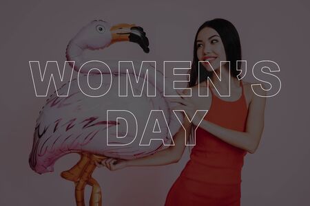 Girl in Red Dress. balloon Pink Flamingo. Pink Background. Celebrating Women's Day. March 8. Smiling Girl with . Surprised Woman.の写真素材