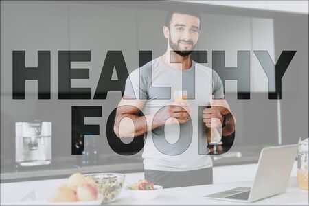 Healthy Food. Athletic Man Posing in the Kitchen. Food on Table. Food is Vegetables and Fruits.の写真素材